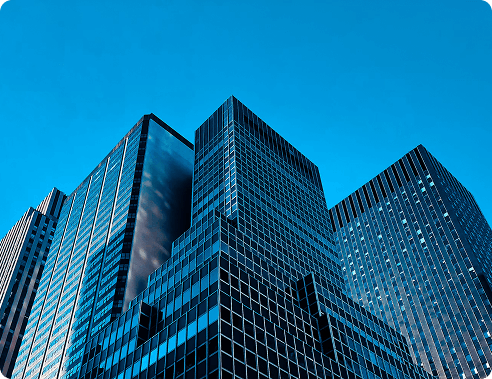 Modern glass skyscrapers viewed from below against a blue sky