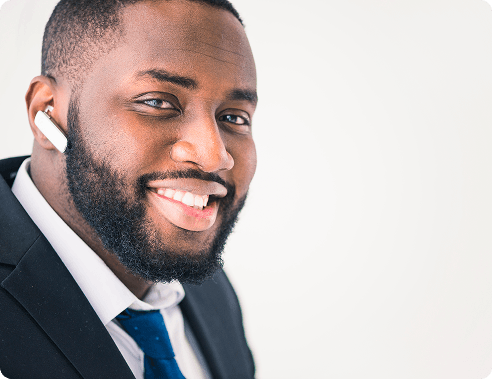 Smiling man in a suit wearing a wireless earbud