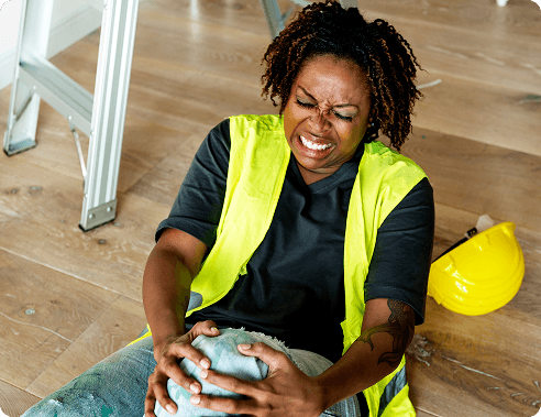 Worker in a high-visibility vest holding an injured knee