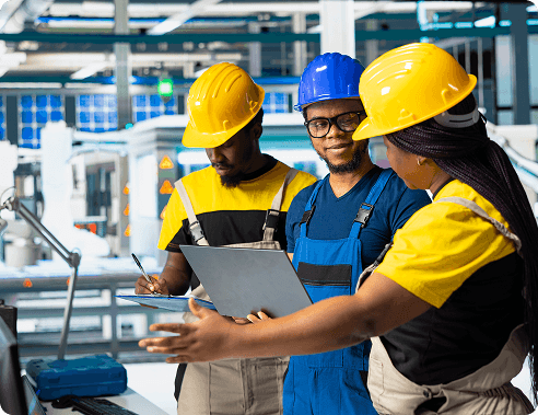 Team of workers in hard hats reviewing a clipboard together