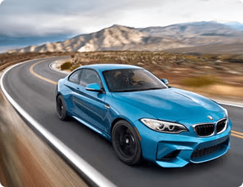 Blue sports car driving along a winding mountain road
