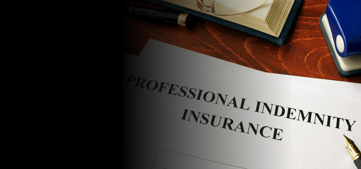Professional indemnity insurance document on a desk with a pen