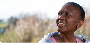 Elderly woman looking up thoughtfully outdoors